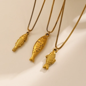Detailed view of three vintage gold fish pendants with varied scale textures on box chains