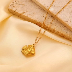 Detailed close-up of a 3D textured gold tropical fish pendant on a minimalist chain