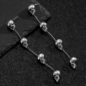 Macro detail van gotische skelet oorbellen met schedel bedeltjes en slangenkettingen