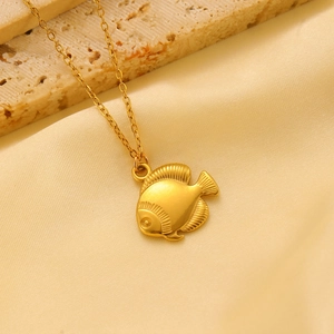 Macro detail of gold stainless steel fish pendant with intricate engraved scales