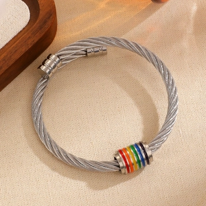 Detalle de brazalete de acero trenzado con anillos vibrantes de esmalte arcoíris