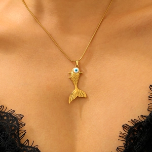 Close-up of gold fish pendant necklace with blue evil eye bead on model's neck
