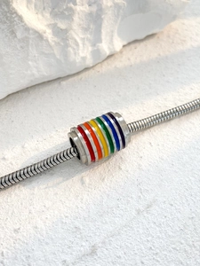 Primer plano de abalorio de esmalte arcoíris en pulsera de cadena de serpiente de plata