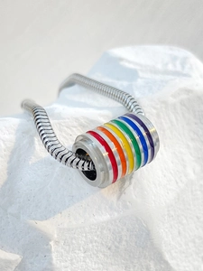 Macro de un colgante cilíndrico de acero plateado con esmalte de arcoíris en cadena de serpiente