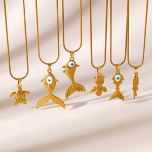 Detailed view of six gold-plated snake chain necklaces with fish and turtle evil eye pendants