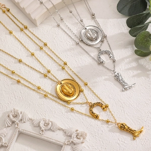 Detail of Western cowboy tiered necklaces featuring hat, horseshoe, and boot charms