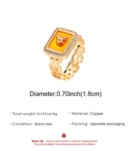 Dettaglio anello in rame placcato oro stile orologio con logo coniglio in smalto arancione
