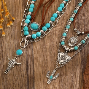 Detailed macro of vintage western turquoise necklace set with bull head and cactus pendants