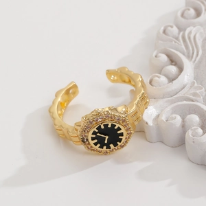 Dettaglio anello a orologio dorato con cristalli rosa su base di marmo