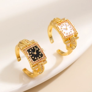 Dettaglio macro di anelli orologio placcati oro con quadranti neri e bianchi e cristalli