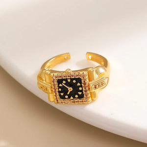 Dettaglio dell'anello stile orologio placcato oro con quadrante nero e zirconi