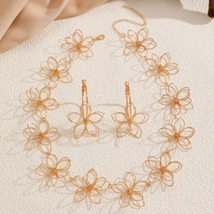 Elegantes Set aus goldener Hohlblütenhalskette und Creolen auf Texturhintergrund