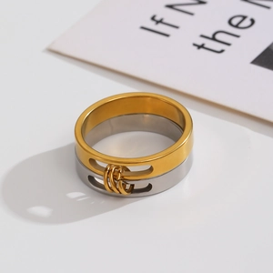 Macro detail of polished two-tone stainless steel ring with hollow slide and gold tiny rings