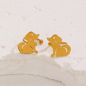 Detailansicht der polierten goldenen Ohrclips in Hundeform aus Edelstahl auf Steintextur