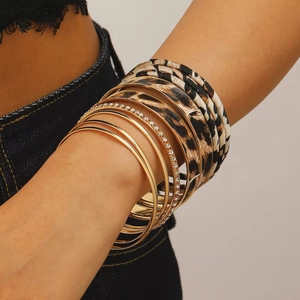 Macro-opname van luipaardprint stoffen armbanden met gouden metalen ringen en strass