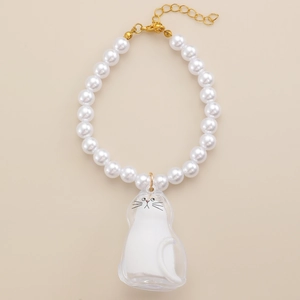 Dettaglio della collana di perle bianche con ciondolo a gatto trasparente e chiusura dorata