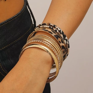Detailweergave van de bohemian gelaagde armbandset met luipaardprint leer en gouden metaal