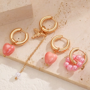 Chic asymmetric gold earrings with pink heart pendant, hummingbird charm, and white pearls