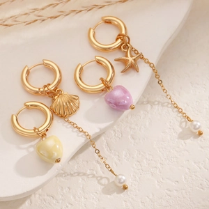 Detail of seashell and starfish drop earrings with white pearls and ceramic hearts