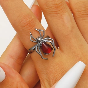 Macro shot of Gothic spider ring with red teardrop gemstone on female hand