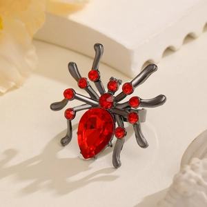Macro detail of gothic spider ring with deep red pear-cut crystal and rhinestones