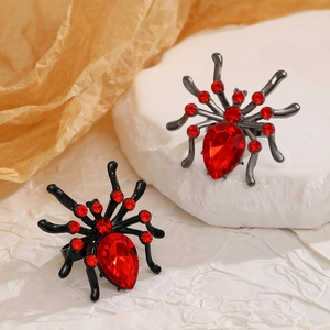 Macro shot of gothic spider rings with red rhinestones and pear-shaped red gemstone