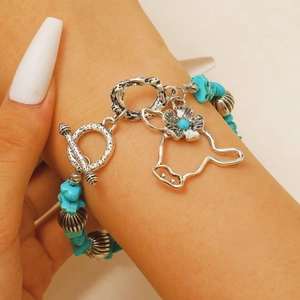 Detail of bohemian turquoise beaded bracelet with vintage silver bull head pendant and OT clasp