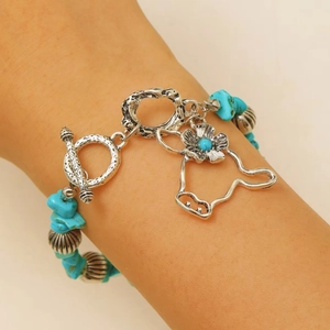 Close-up of Western cow head pendant and turquoise beads on vintage style bracelet