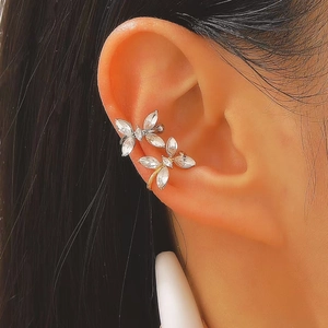Macro view of butterfly ear clips with clear zircon stones on ear cartilage