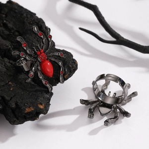 Macro shot of gothic spider ring with red gems on black wood and dark branches