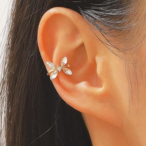 Detail of gold butterfly ear cuff with zircon stones on model ear without piercing