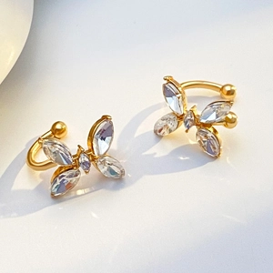 Minimalist gold butterfly ear clips with zircon stones on a clean white background