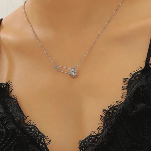 Detalle de collar de clip plateado con colgante de margarita pequeña sobre la clavícula femenina