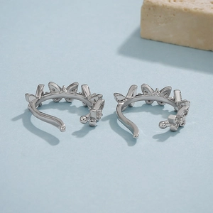 Detailed view of silver butterfly ear cuffs with sparkling cubic zirconia stones