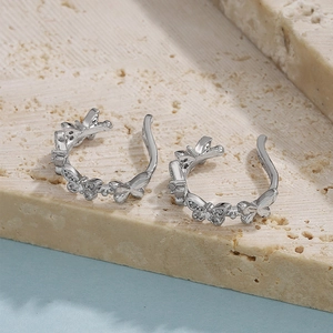 Macro detail of silver butterfly clip earrings with sparkling cubic zirconia on stone