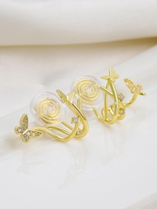 Detailed macro shot of gold butterfly ear clips with zircon and soft silicone pads