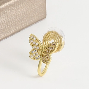 Close-up of golden butterfly ear clip with cubic zirconia and transparent pad