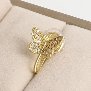 Macro shot of gold butterfly ear cuff with sparkling zircon inlay in a velvet box