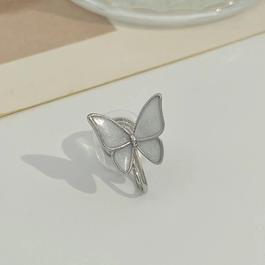 Macro view of silver butterfly clip earrings with white glitter wings and fine metallic edge