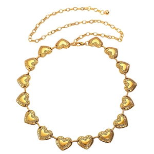 Detail der goldenen Vintage-Metall-Taillenkette mit geprägten Herzmustern und Blumen