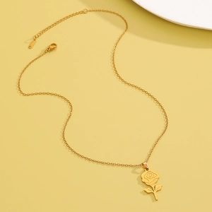 Detail of the gold flower pendant necklace showing the S.STEEL material hallmark tag