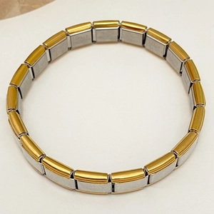 Makro-Detailansicht des italienischen Charm-Armbands mit Edelstahlmodulen in Gold und Silber
