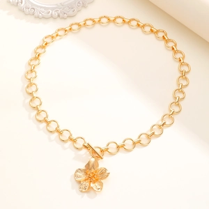 Dettaglio della collana con fiore dorato, petali testurizzati e chiusura a levetta OT