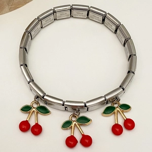 Detail eines Edelstahl-Charm-Armbands mit roten Kirsch-Anhängern und Gliederketten