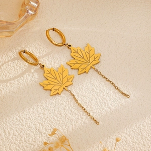 Detail view of 18k gold plated maple leaf earrings with long chain tassels and leaf veins