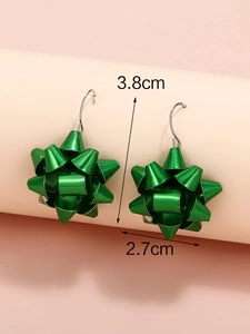 Vista macro degli orecchini a fiocco festivo verde brillante con misura di 3,8 cm