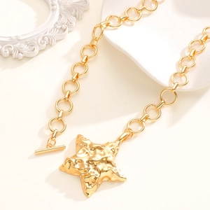 Dettaglio della collana con stella dorata, trama martellata e chiusura a levetta