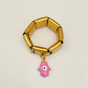 Detail eines vergoldeten Edelstahlrings mit rosa Hamsa-Hand und Evil Eye Anhänger