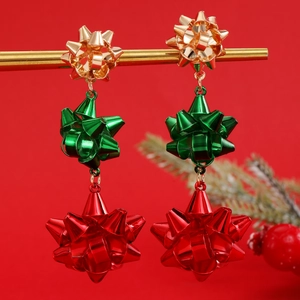 Vista macro dettagliata degli orecchini a fiocco di Natale a tre strati in rosso verde oro