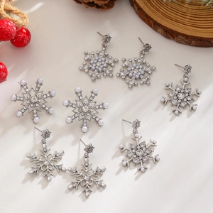Macro detail of snowflake earrings with zircon and pearls in a festive setting